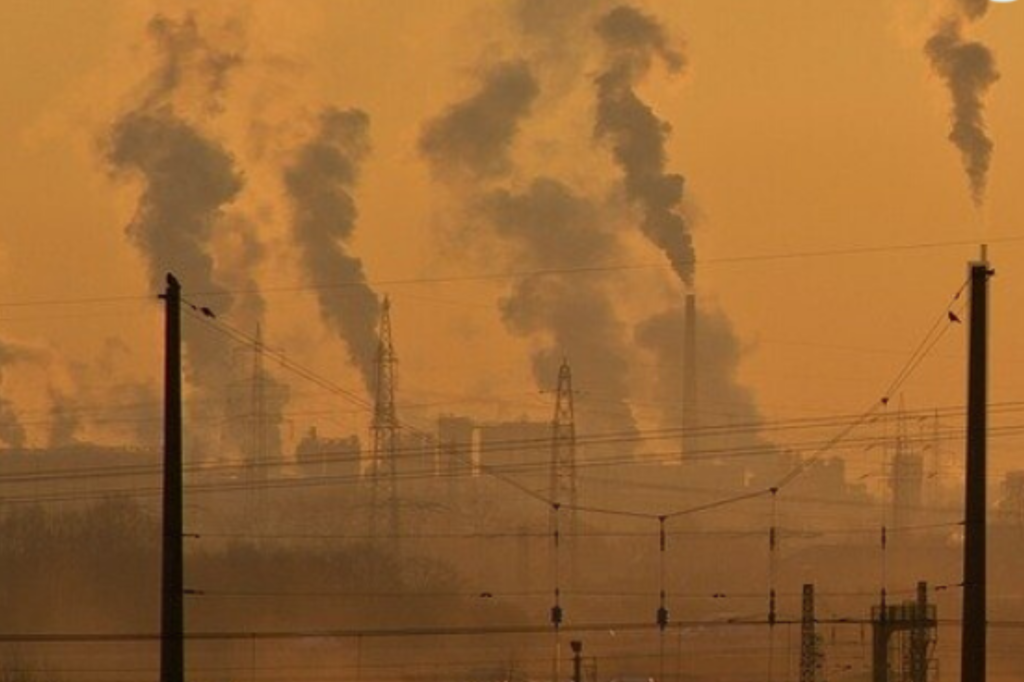 Smoke being blown into the air against a sunset backdrop.