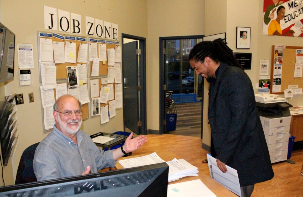 A LEC staff members greets a participant at the job fair.