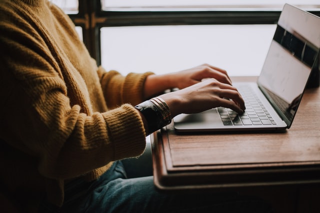 Person at a desk typing on a laptop