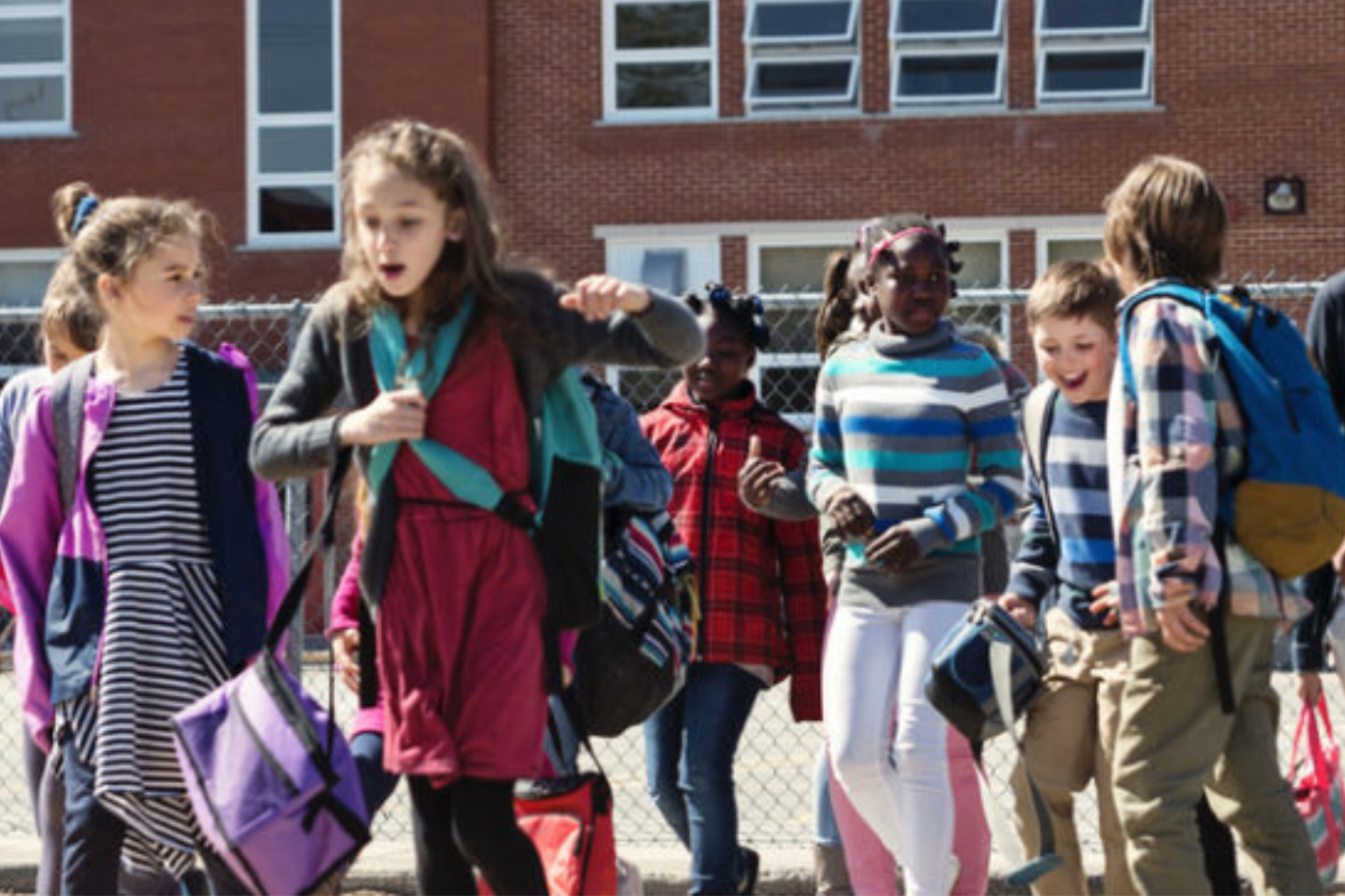 A group of children in front of a school.