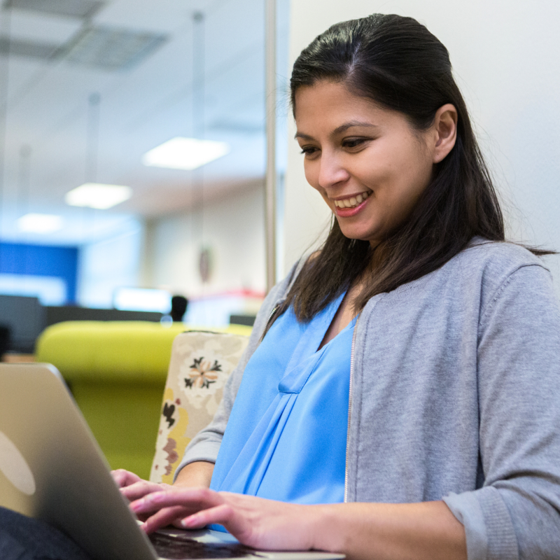 Woman sitting in front of a laptop computer looking excited